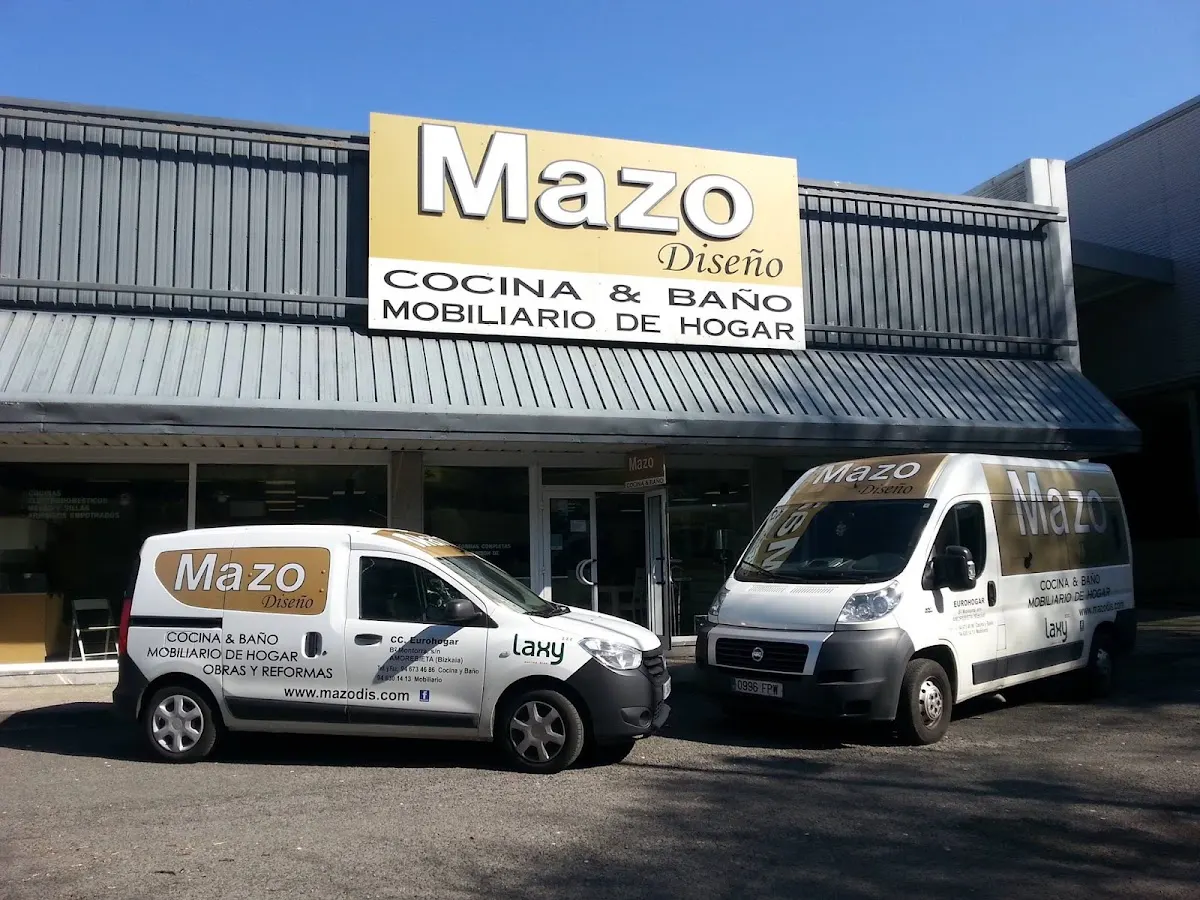 Fachada de Mazo Diseño con el rótulo y vehículos del negocio