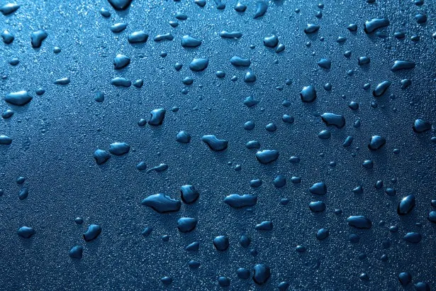Superficie azul cubierta de gotas de agua.