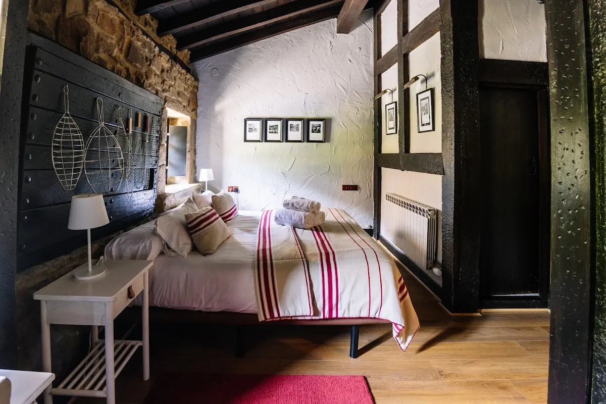 Habitación de Mendi Goikoa Bekoa con cama doble y vigas de madera