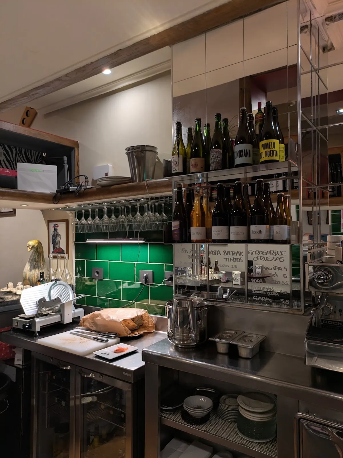 Interior de Miñe Taberna, con barra, botellas y copas.