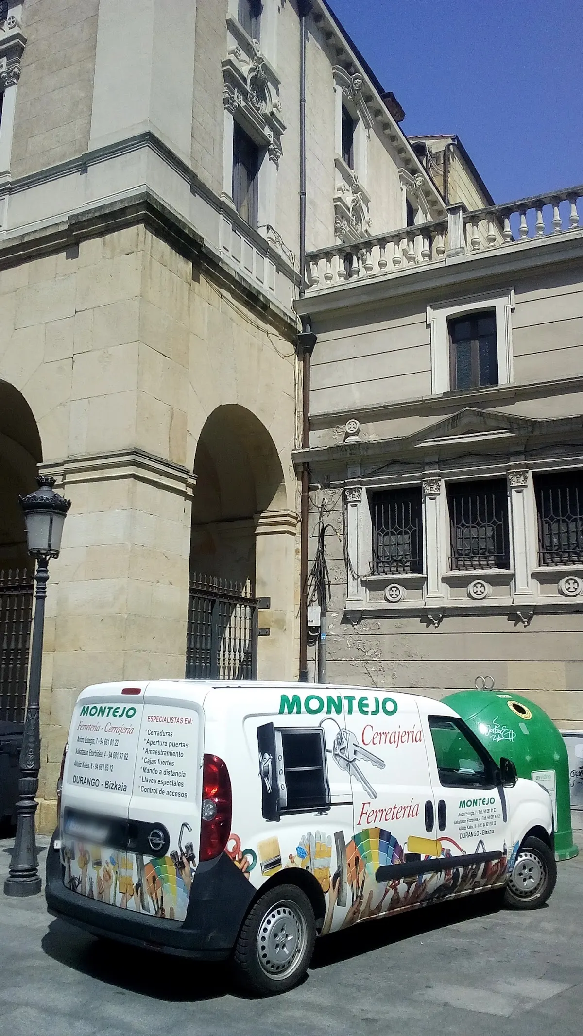 Furgoneta rotulada de Montejo Ferretería Cerrajería junto a un edificio