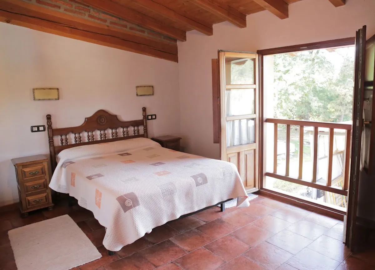 Habitación de Murueta Baserria con cama y salida a un balcón