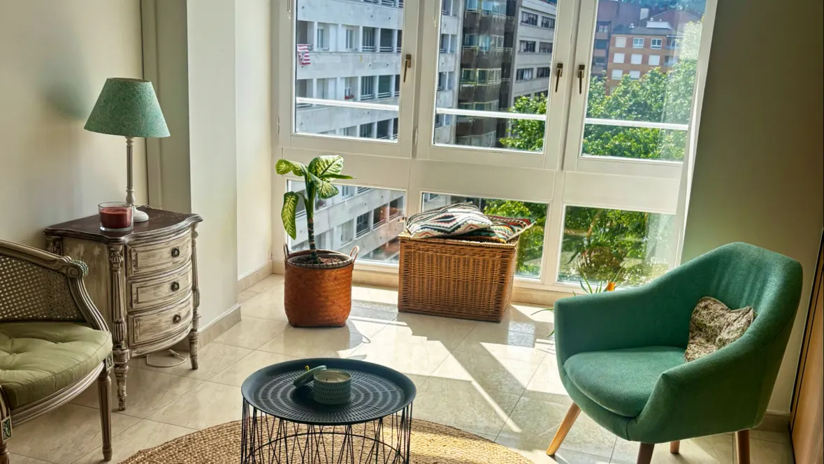 Sala de espera de Naiara Garro Psicóloga, con sillones verdes y una mesa junto a la ventana.