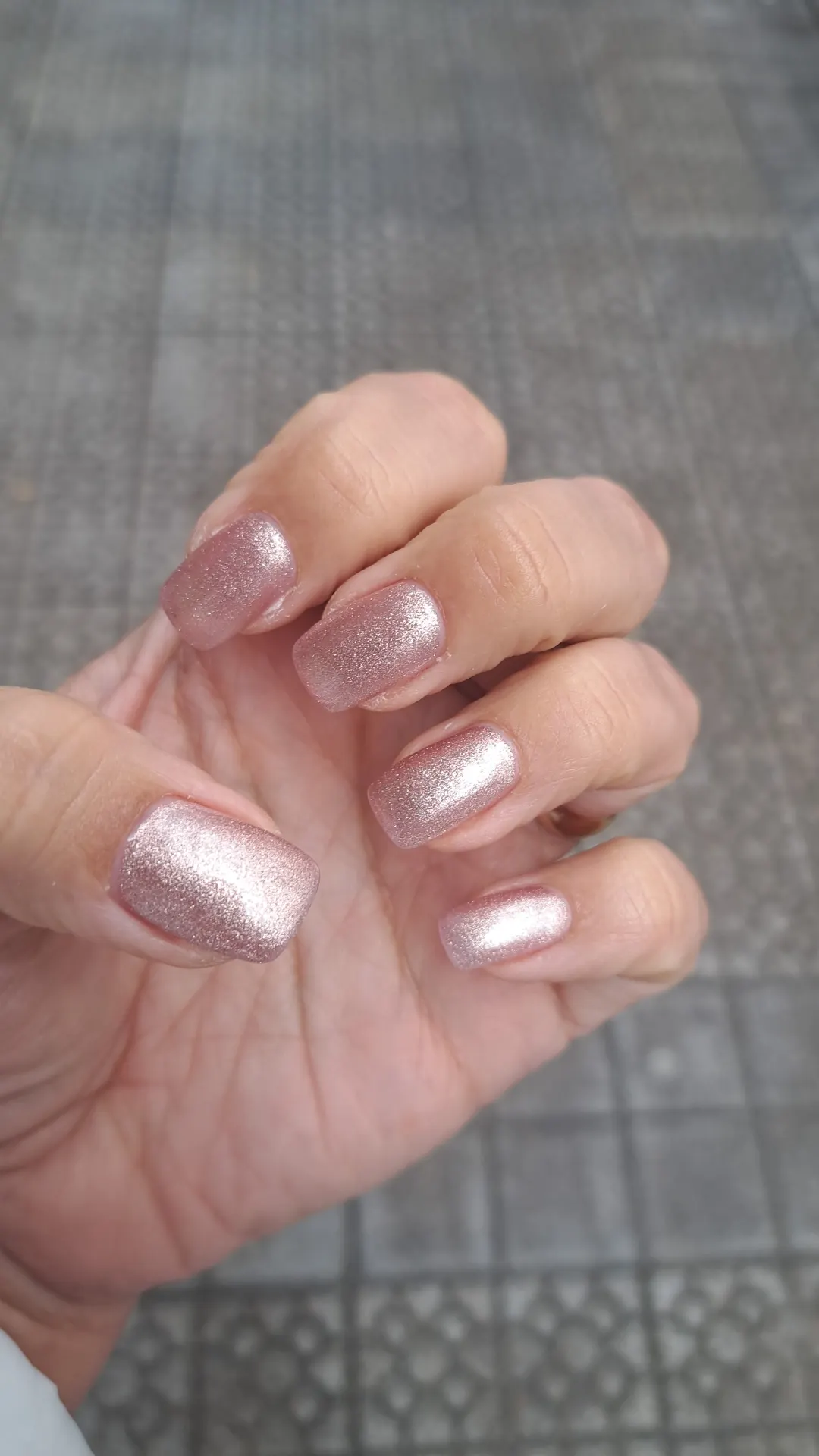 Uñas con esmalte rosado brillante en una mano en Nails Siona
