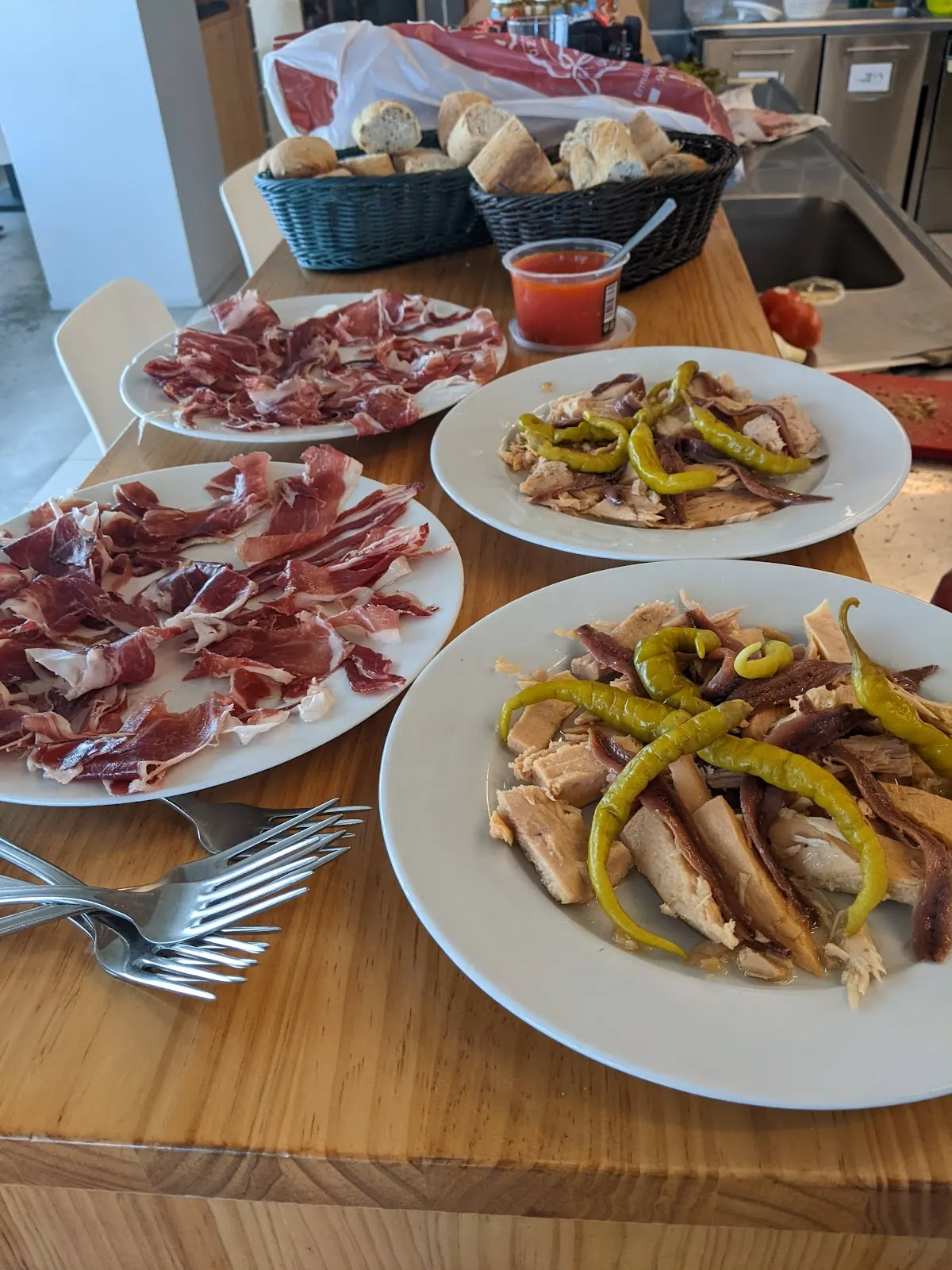Platos de jamón y pescado con guindillas y pan en Napar Txoko Elkarte Kulturala