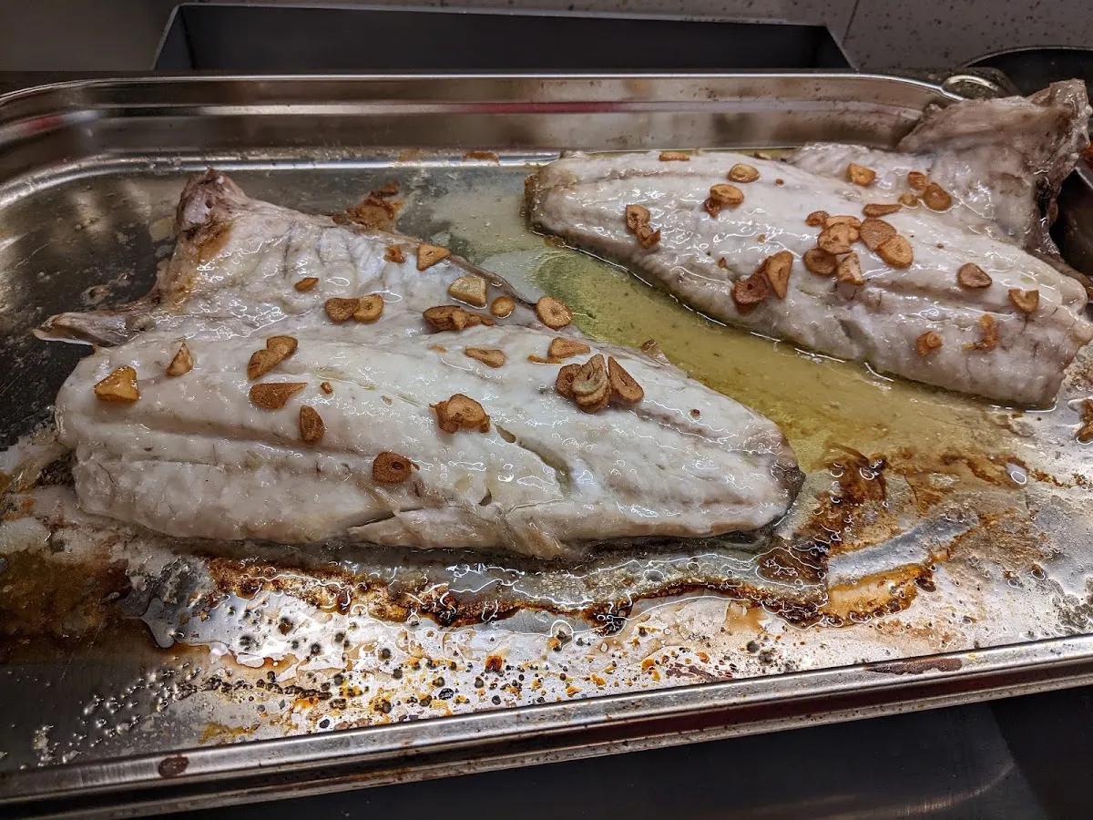 Pescado asado con ajo en una bandeja de Napar Txoko Elkarte Kulturala