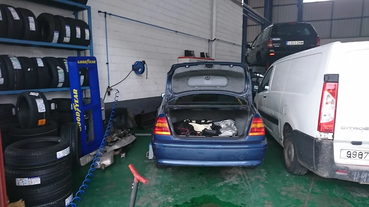 Neumáticos y un coche en el área de trabajo del taller