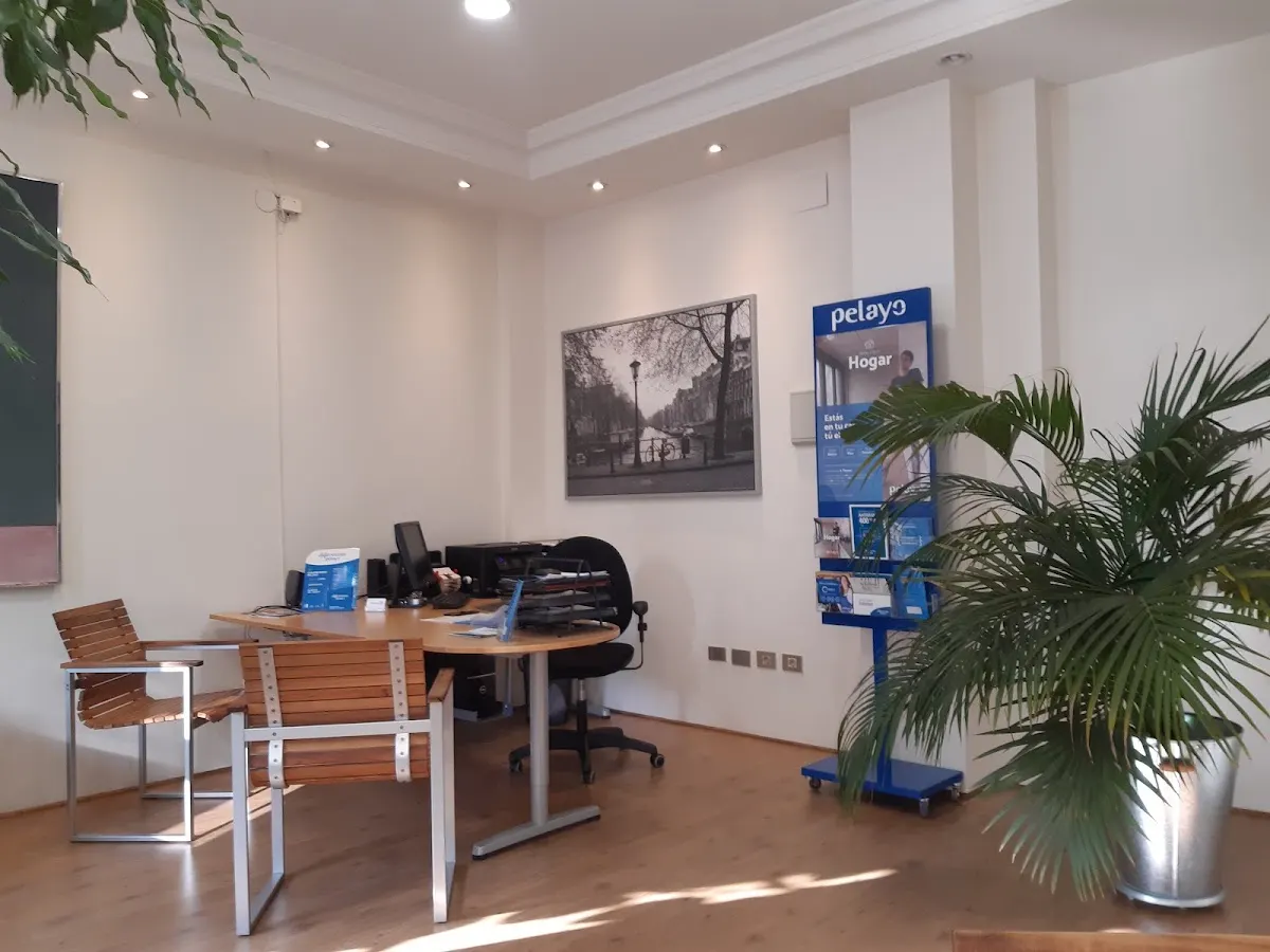 Interior de la oficina de Seguros Pelayo con mesa de atención y mostrador