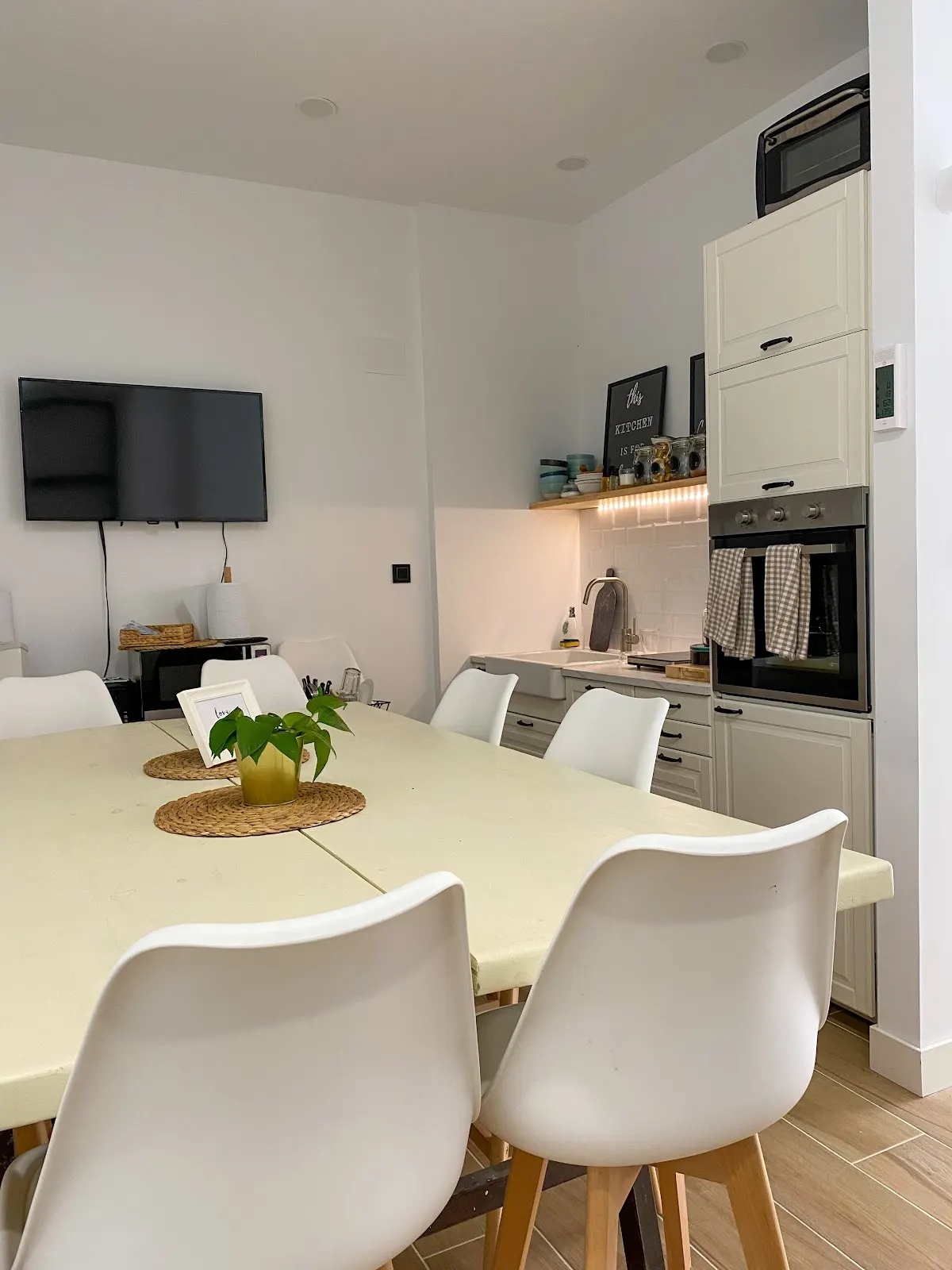 Comedor y cocina de una vivienda con mobiliario blanco.