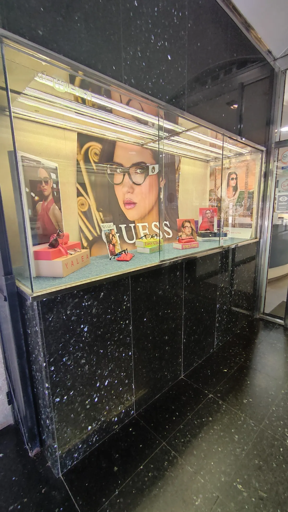 Escaparate de Opticalia Durango con gafas y carteles de marcas de óptica.