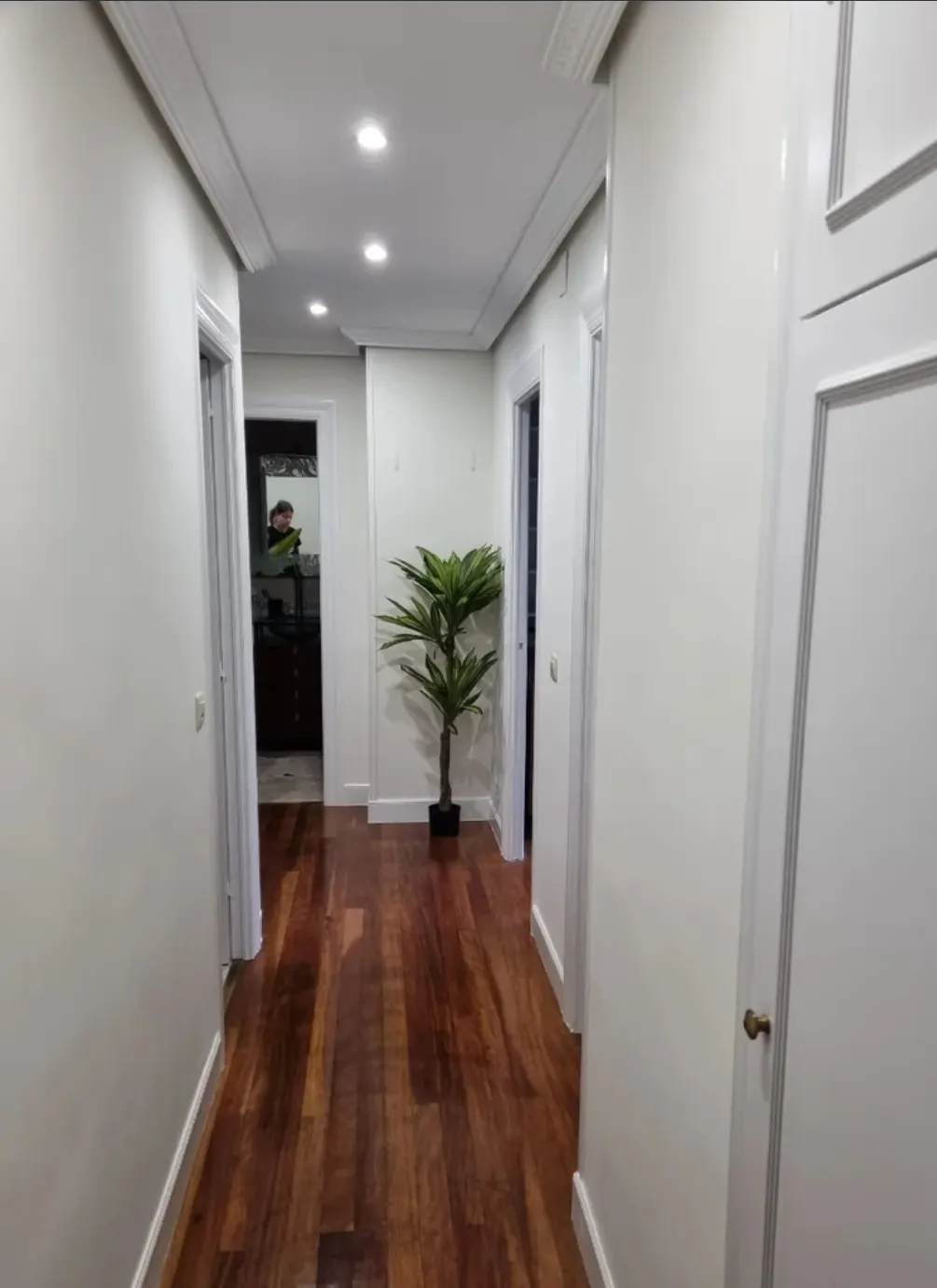 Pasillo interior acabado con paredes blancas y suelo de madera, asociado a P.Duarte pintura y decoraciones