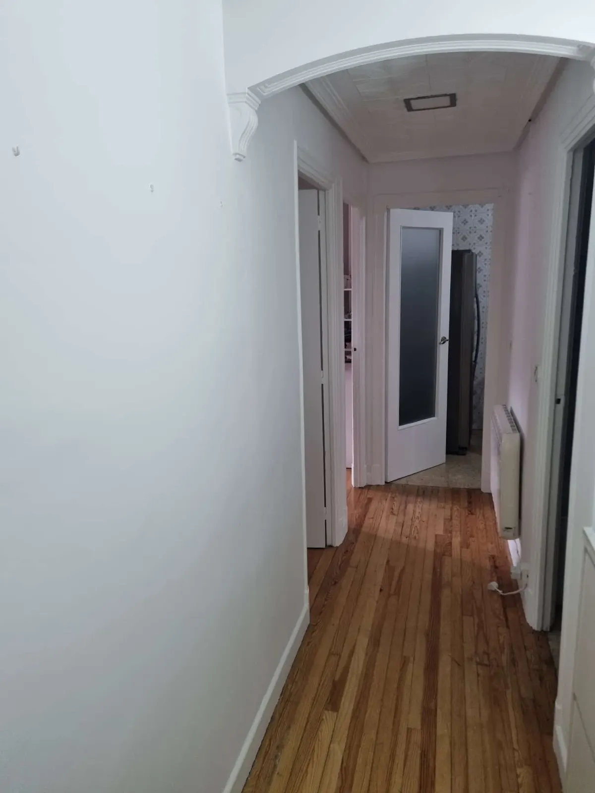 Pasillo con paredes claras y suelo de madera