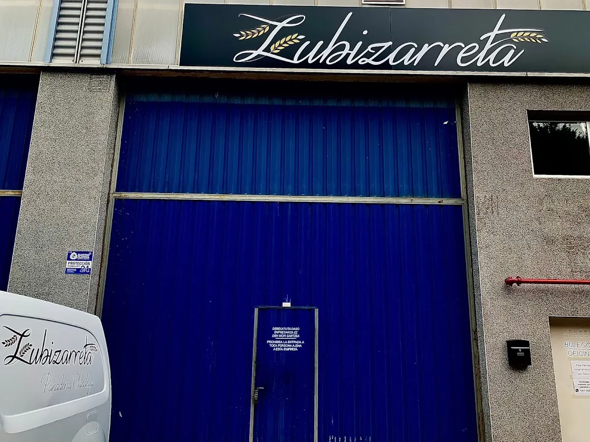 Fachada de Panaderia Zubizarreta en Zaldibar, con el acceso cerrado por una puerta azul.