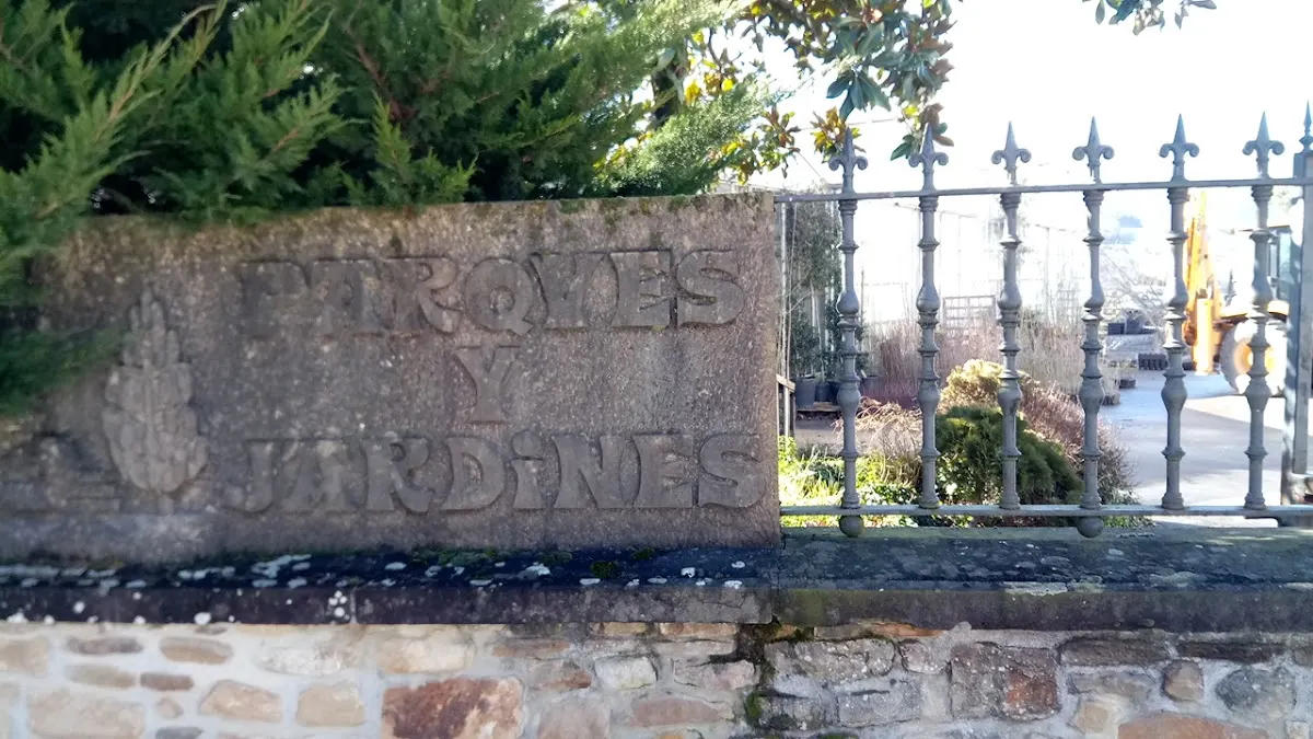 Muro de piedra y verja de hierro junto a vegetación, en una imagen asociada a Parques y Jardines de Abadiano.