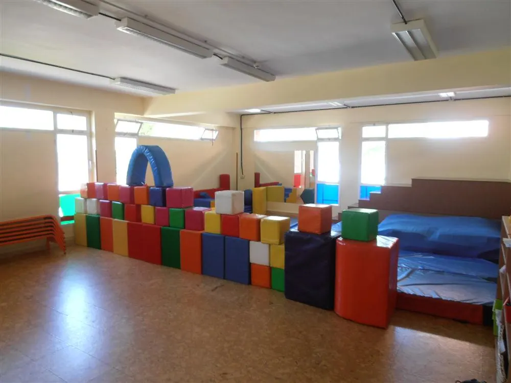 Interior de la haurreskola con módulos acolchados de juego y zona de colchonetas.