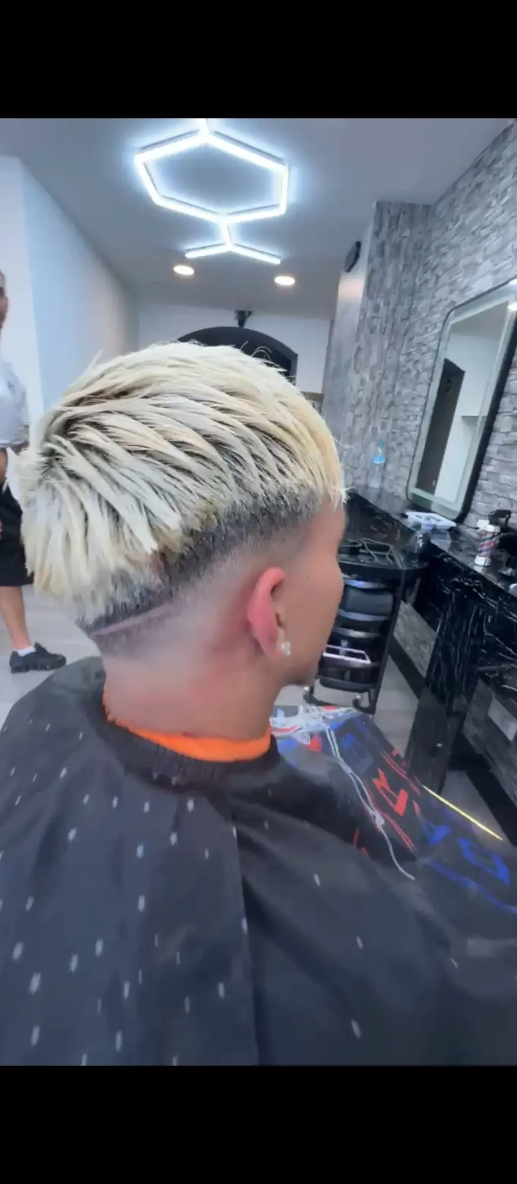 Corte con cabello rubio platino y degradado en Peluquería Barbería Anass