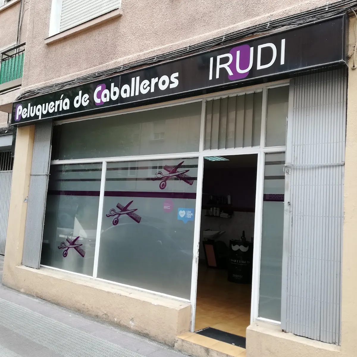 Fachada de Peluquería Irudi en Durango, con el rótulo de peluquería de caballeros.