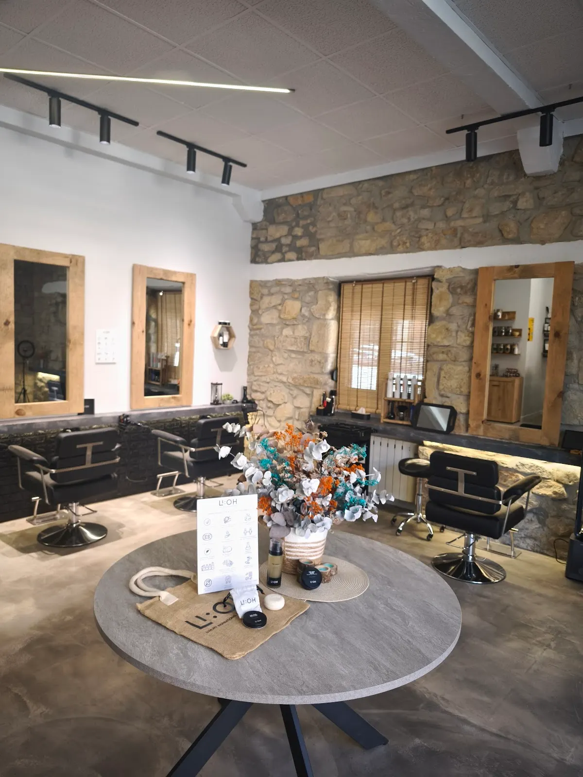 Interior de Peluquería Orgánica Indala, con sillones de peluquería y una mesa central.