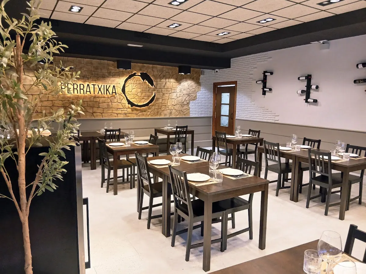 Comedor de Perratxika con mesas de madera y paredes de piedra