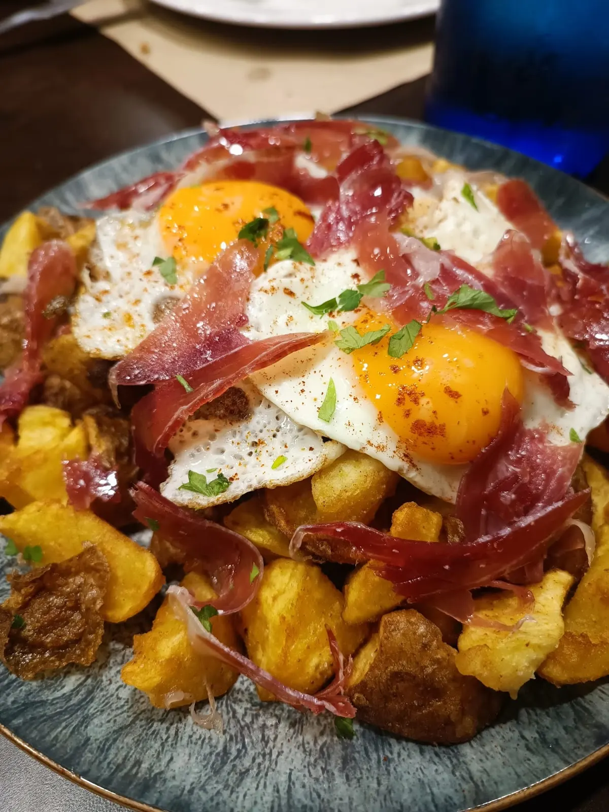 Plato de patatas con huevos y jamón en Perratxika