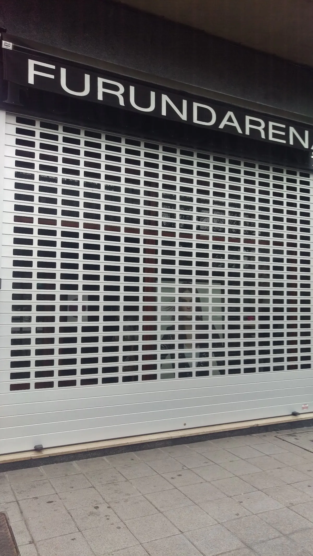 Persiana metálica de rejilla en la fachada de Furundarena