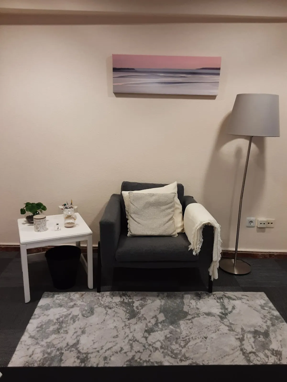 Sillón y mesa auxiliar en una sala de Psicóloga Aditya Serra.