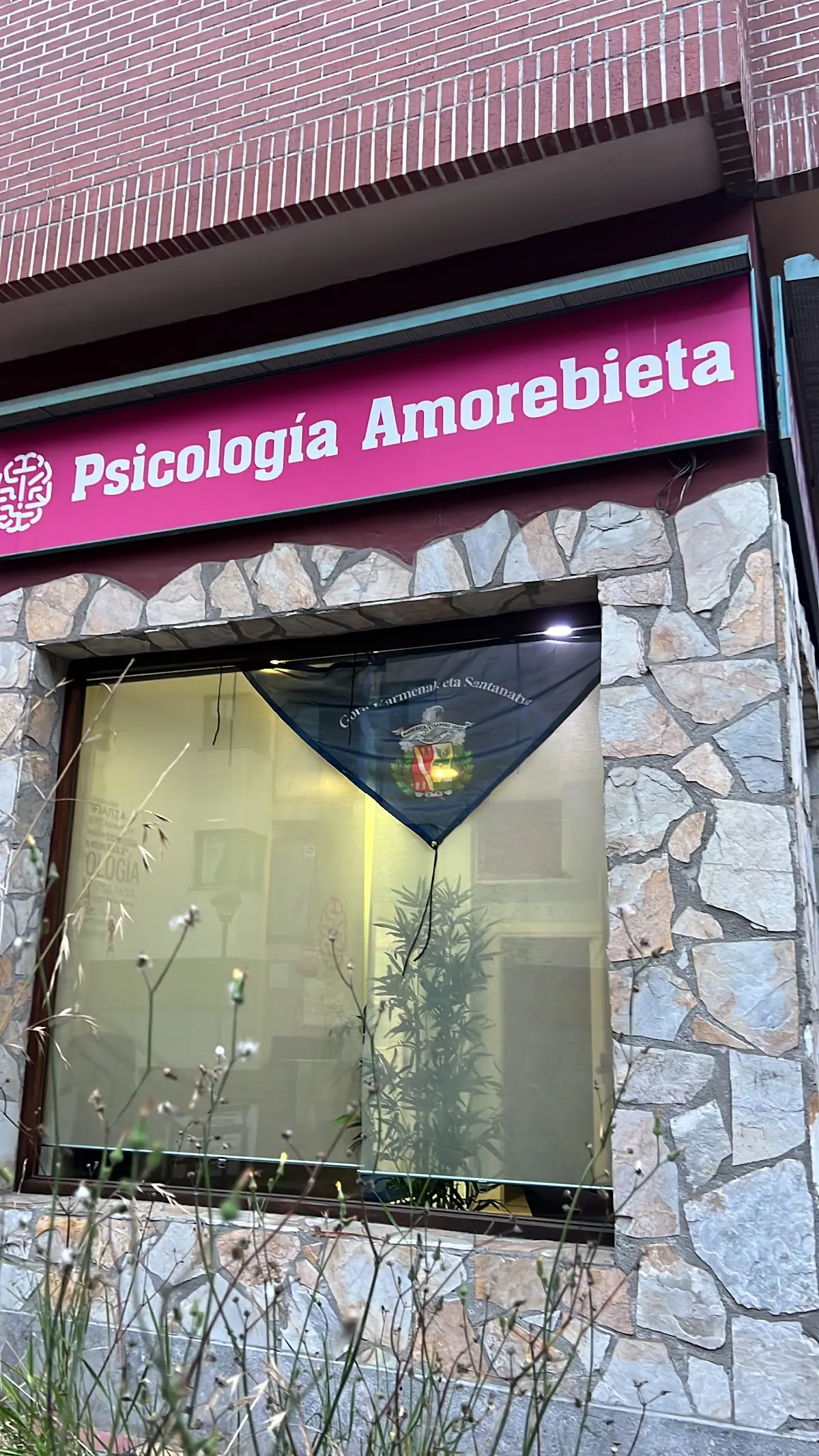 Entrada de Psicología Amorebieta, con el rótulo del centro sobre el escaparate.
