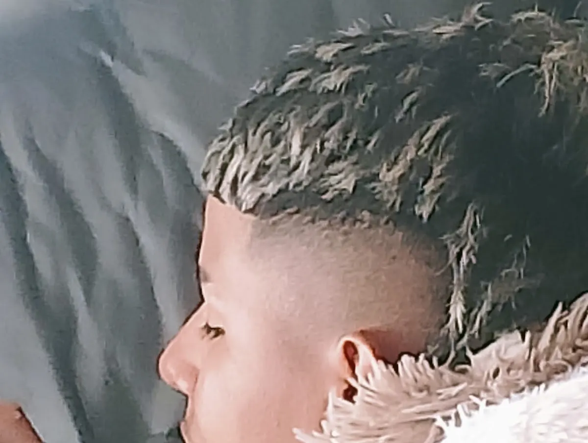 Primer plano de una persona con un corte de pelo corto y degradado.