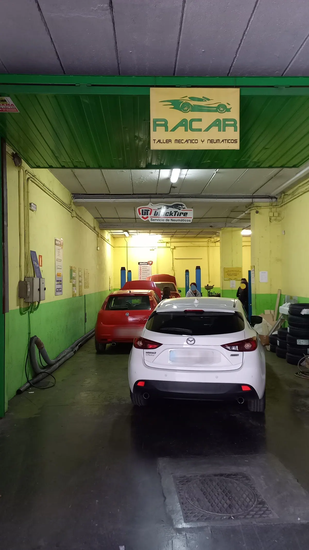 Entrada del taller Racar Durango con varios coches en reparación