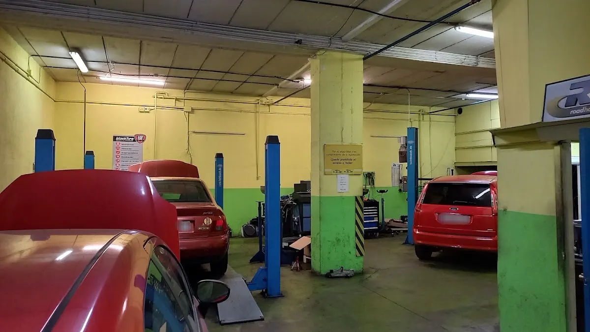 Interior del taller Racar Durango con vehículos y elevadores