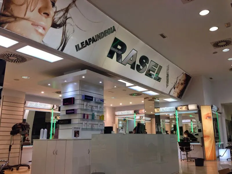 Interior de Rasel Peluquerías, con mostrador y puestos de peluquería.
