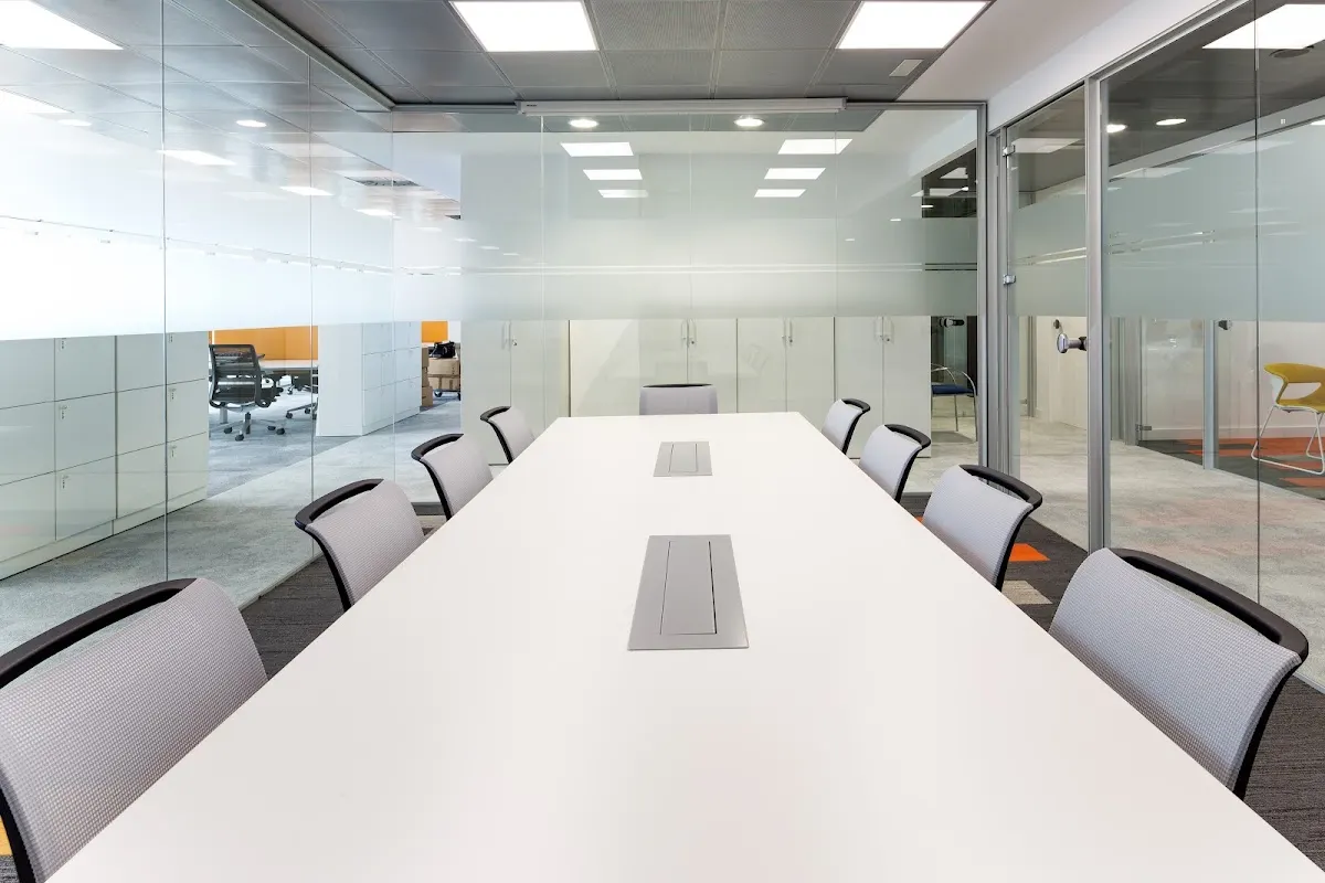 Sala de reuniones de Rauman con mesa alargada y paredes de cristal.