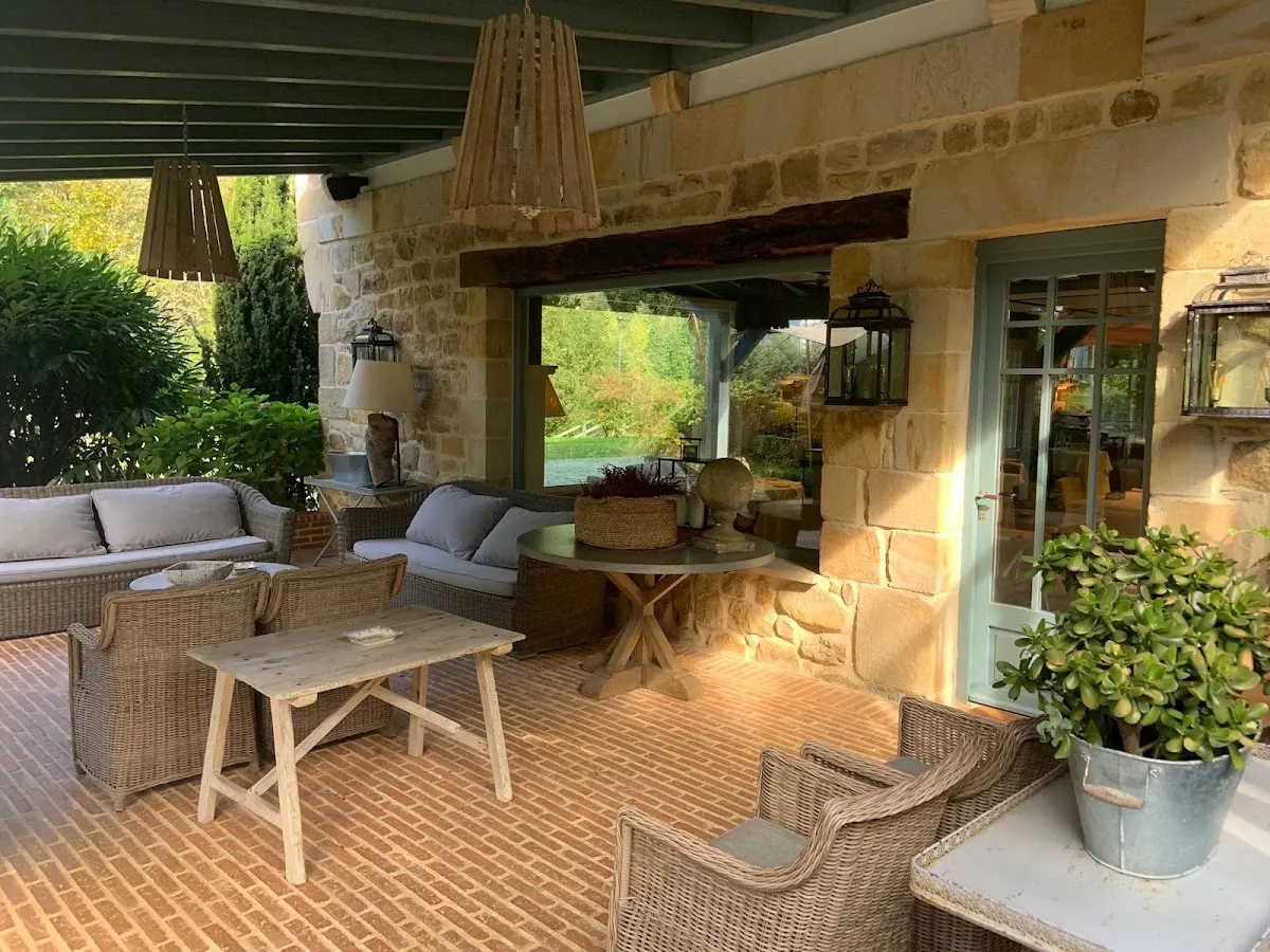 Terraza cubierta del Restaurante Aboiz con mesas y sillones de exterior.
