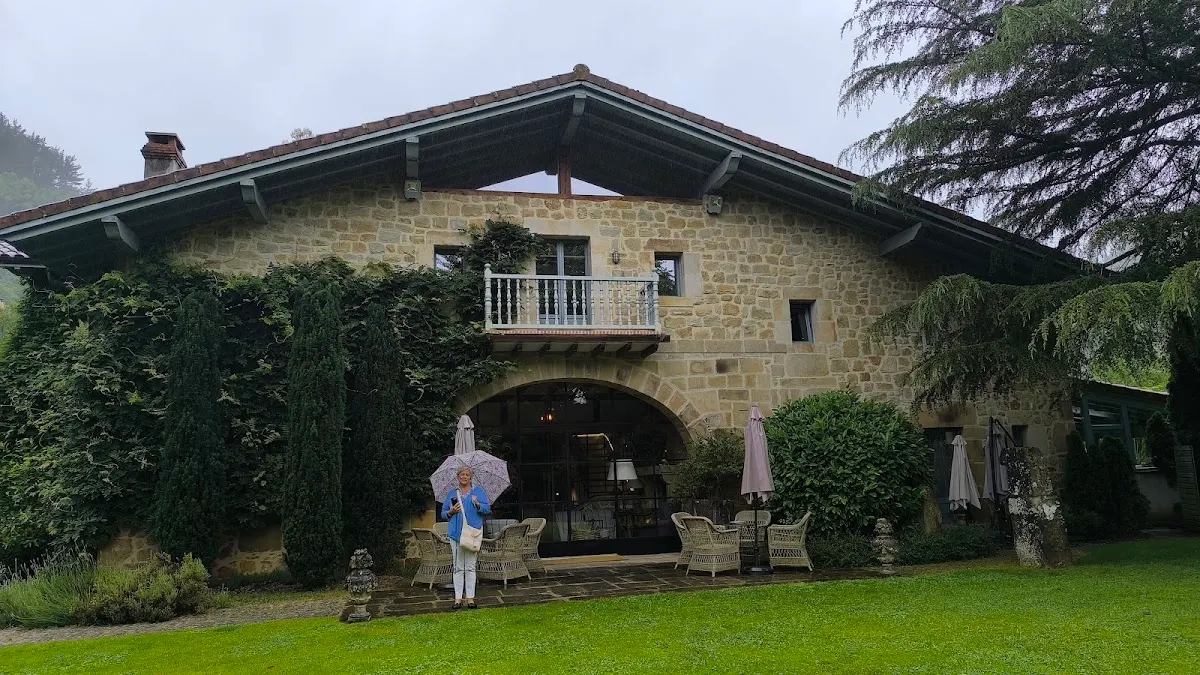 Exterior del Restaurante Aboiz, con fachada de piedra y zona ajardinada.