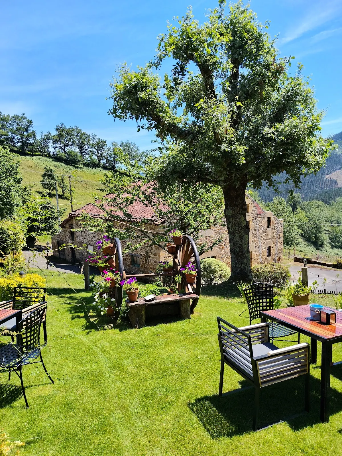 Jardín y terrazas exteriores del Restaurante Akebaso, rodeados de vegetación y con vistas al caserío.