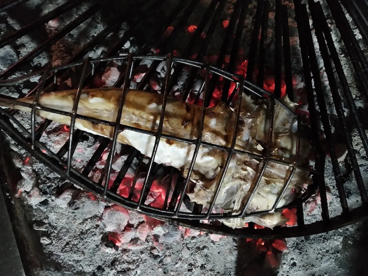 Pollo asado cocinándose a la brasa en el Asador Azken