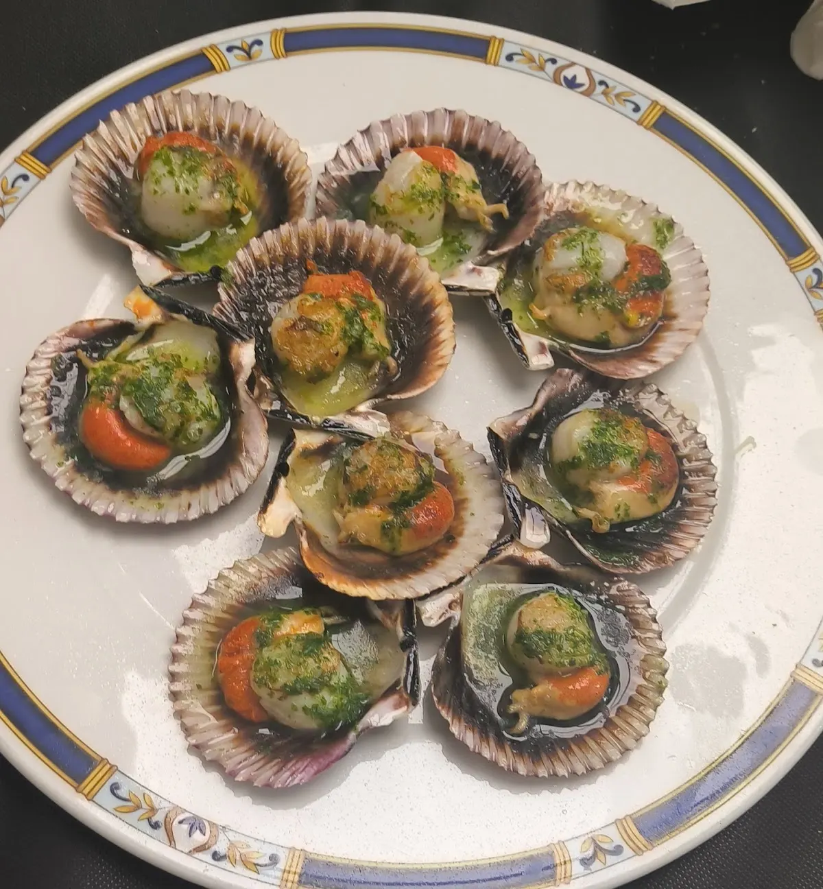 Plato de zamburiñas con salsa y hierbas en el Restaurante Bar Aboro.