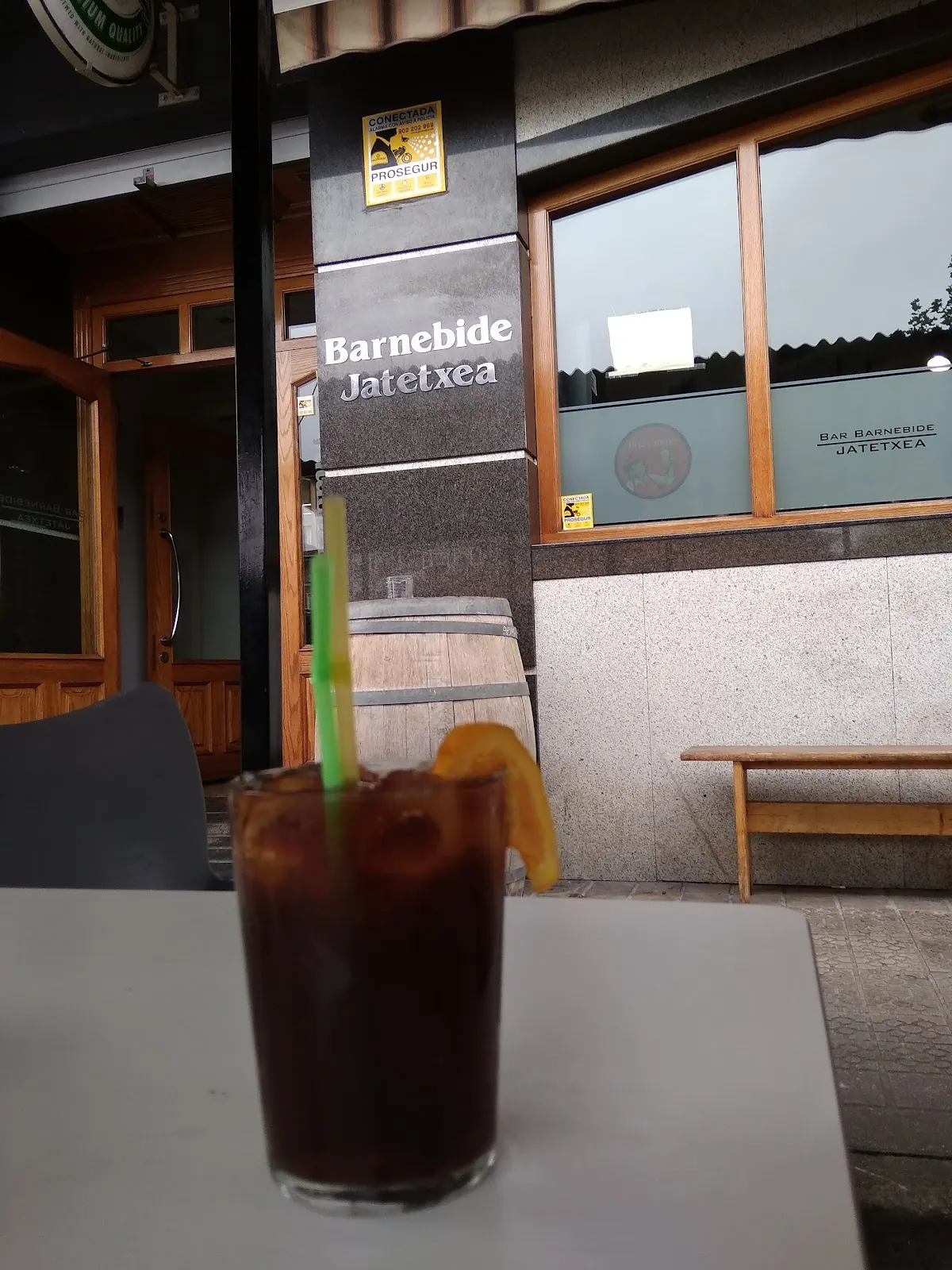 Exterior de Barnebide Jatetxea con una bebida sobre la mesa.