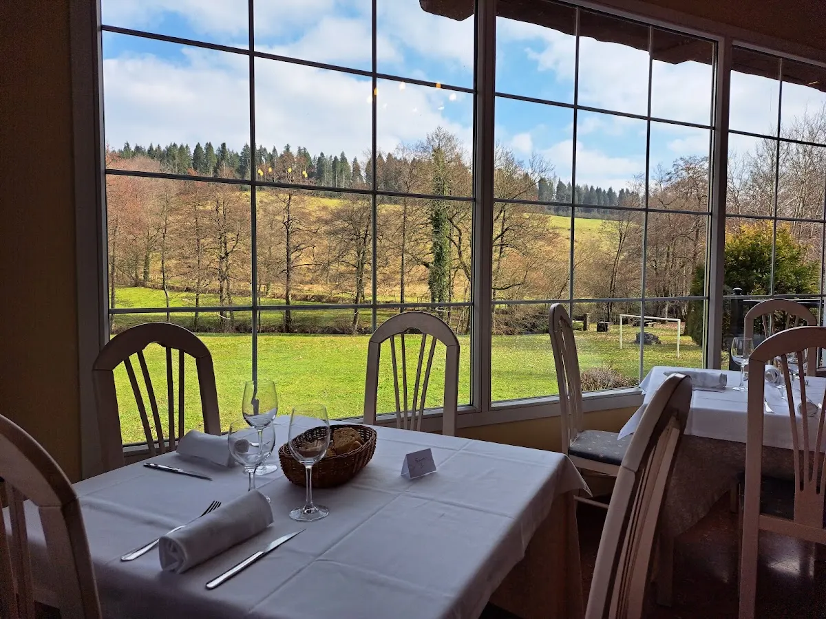 Comedor de Basaguren Jatetxea con mesas junto a grandes ventanales y vistas al paisaje