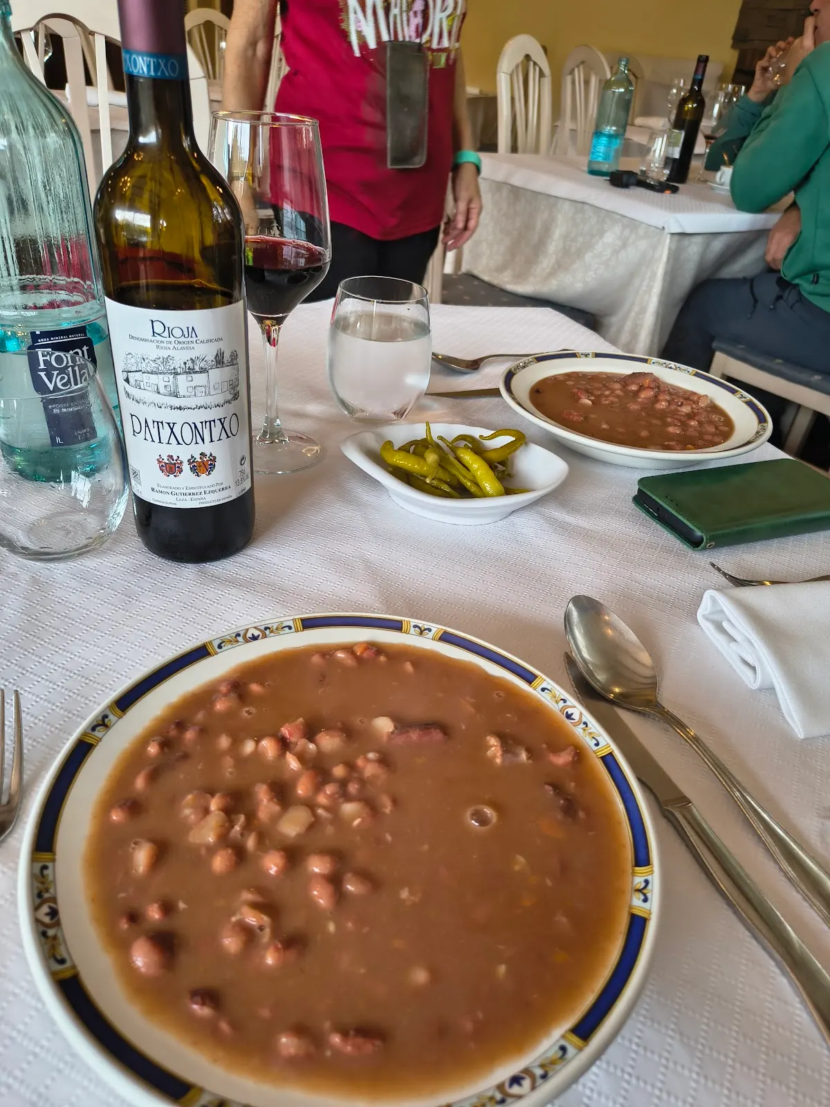 Platos de cuchara y bebidas servidos en una mesa de Basaguren Jatetxea