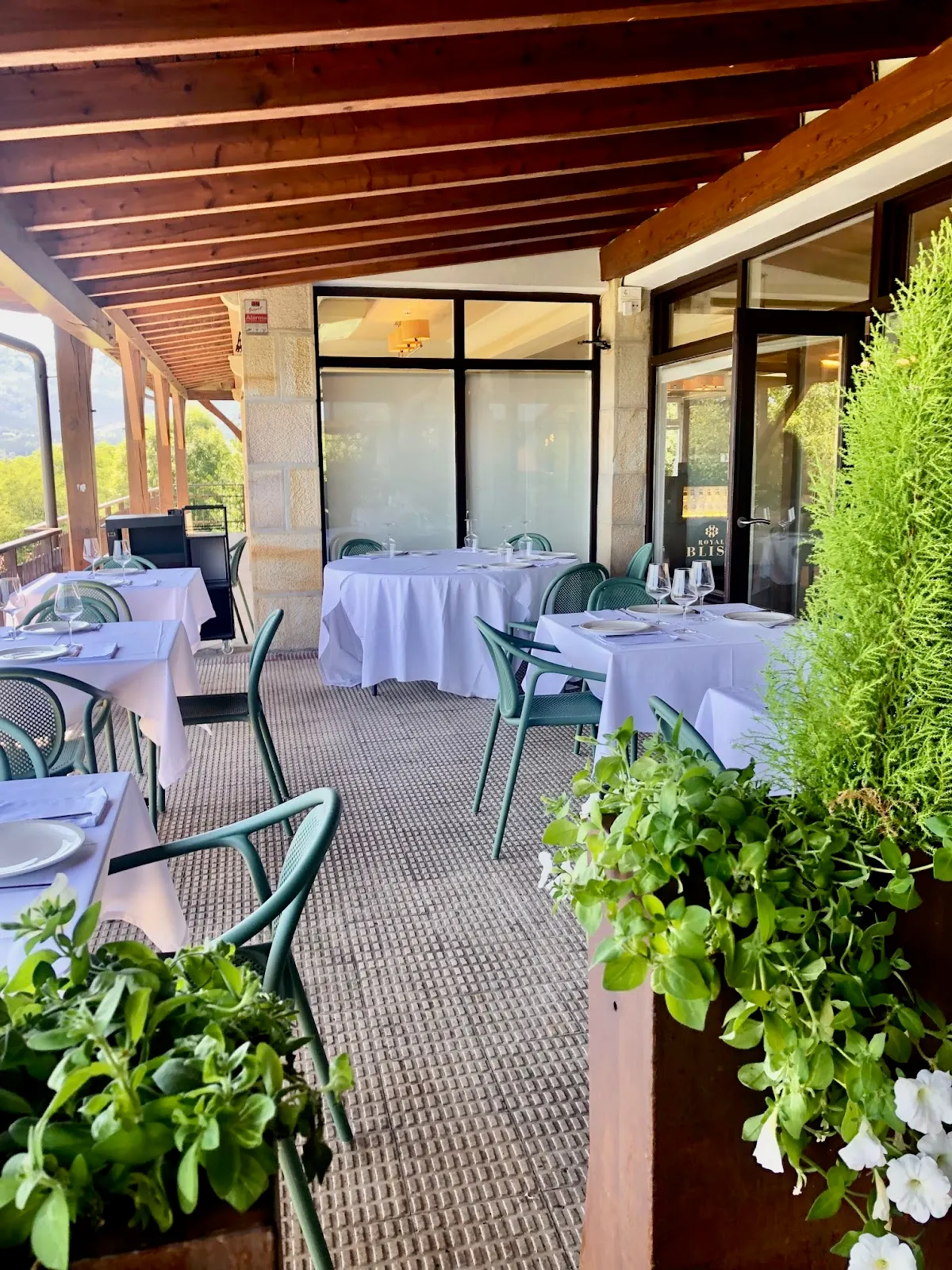 Terraza de Restaurante Ikuspegi Berria con mesas preparadas y plantas, en Goiuria