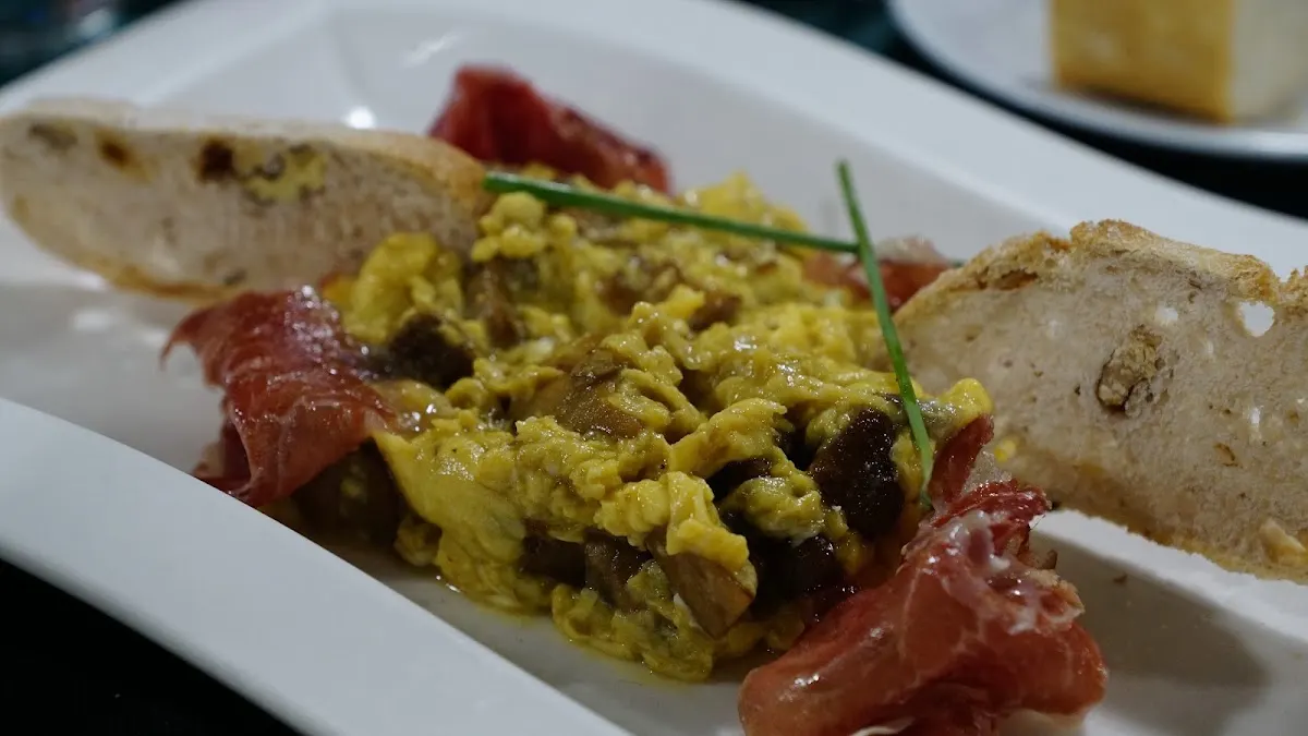 Plato de revuelto con jamón y pan en Restaurante Katxarro