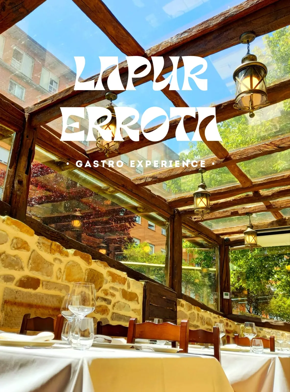 Comedor de Lapur Errota con mesas junto a una estructura de madera y piedra.