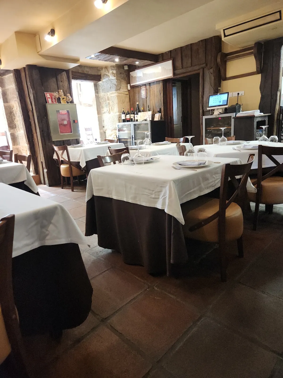 Interior del restaurante Lapur Errota con mesas preparadas para comer.