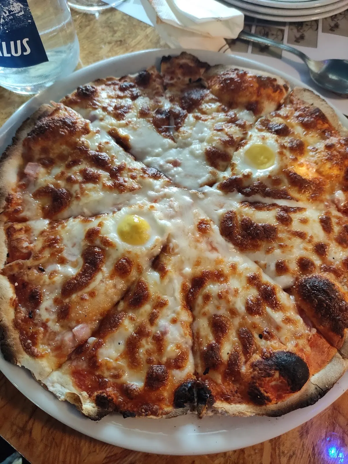 Pizza con queso y huevo servida en un plato