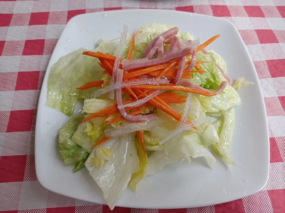 Ensalada con lechuga, zanahoria y cebolla en Restaurante Nuevo Siglo