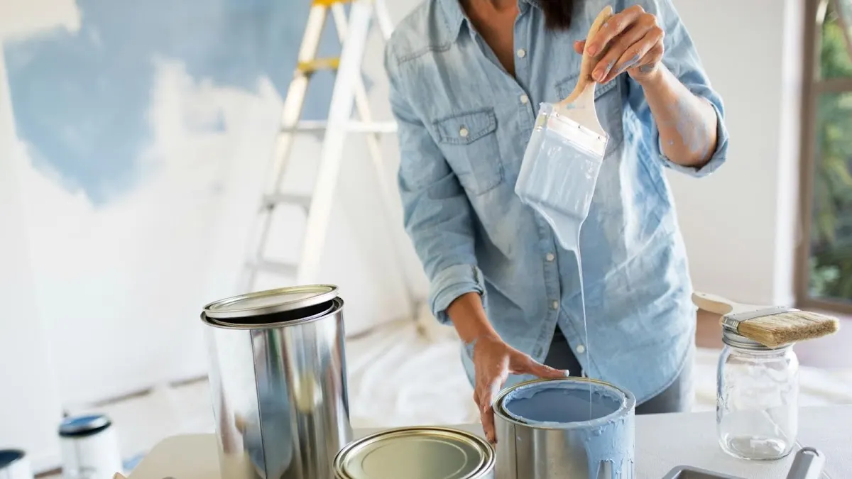 Profesional aplicando pintura en una pared con botes y herramientas; imagen asociada a Rocha e Hijos.