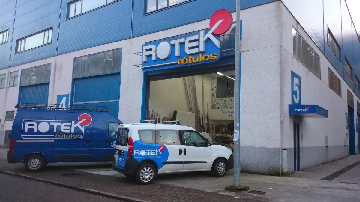 Fachada de Rotek Rótulos en Mallabia, con vehículos rotulados aparcados delante.