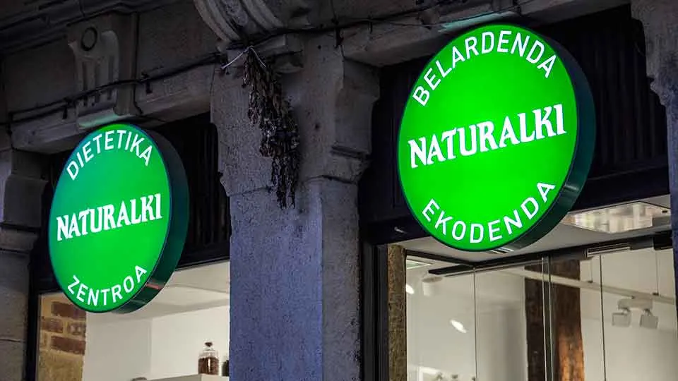 Rótulos verdes de Dietetika Naturalki en la fachada de un local.