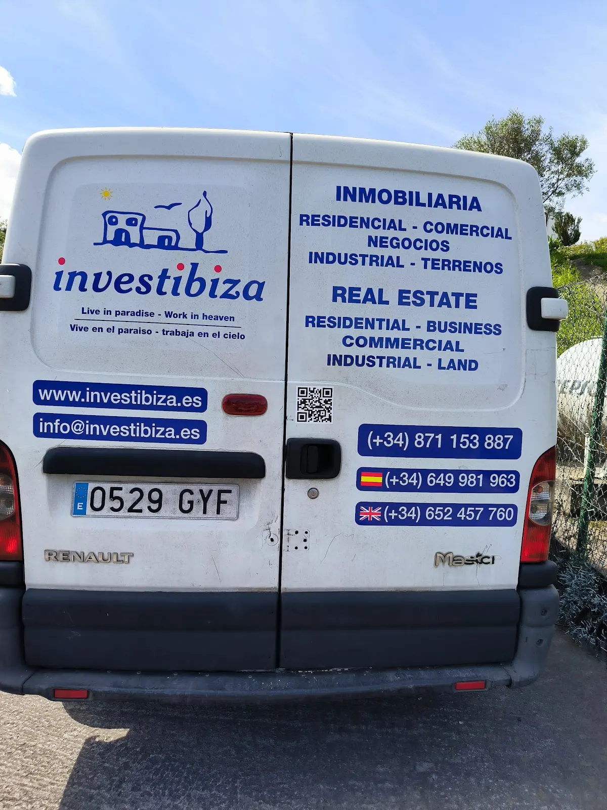 Furgoneta con rótulos de Investibiza vista por detrás.